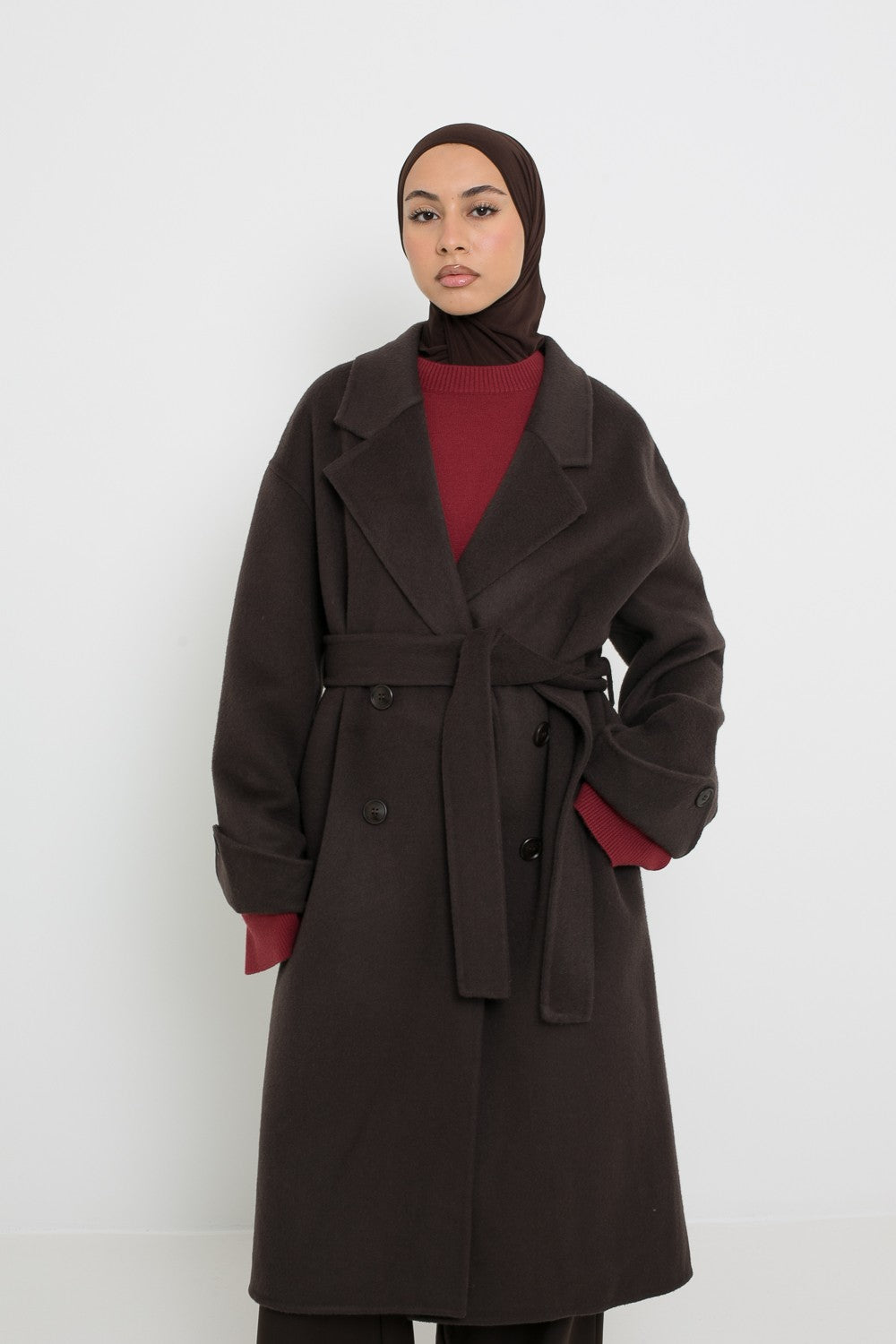 Manteau long en laine marron foncé , détail col et ceinture. Boutique de prêt à porter classe et tendance pour femme musulmane.