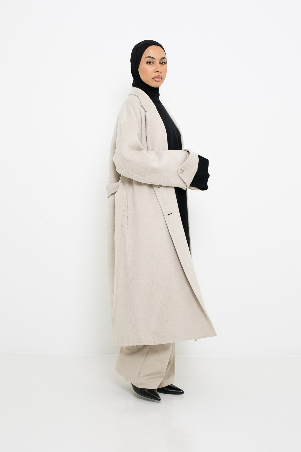 Manteau long en laine coupe large vue de profil. Boutique de prêt à porter pour femme musulmane.