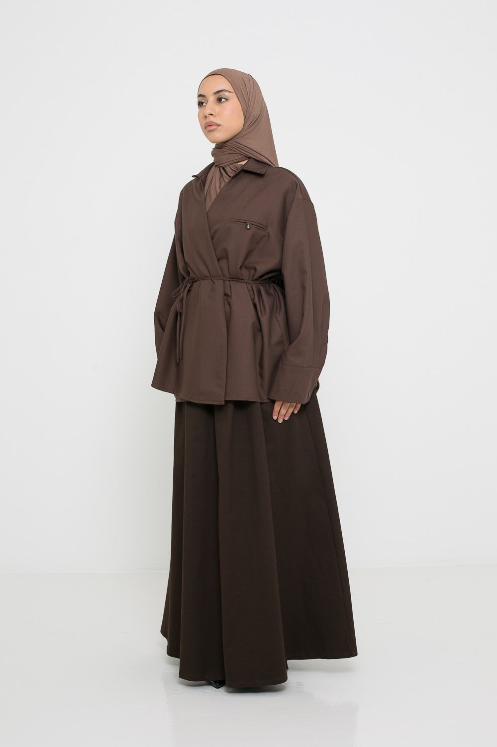 Surchemise marron pour femme musulmane portée avec une jupe en coton vue de profil.