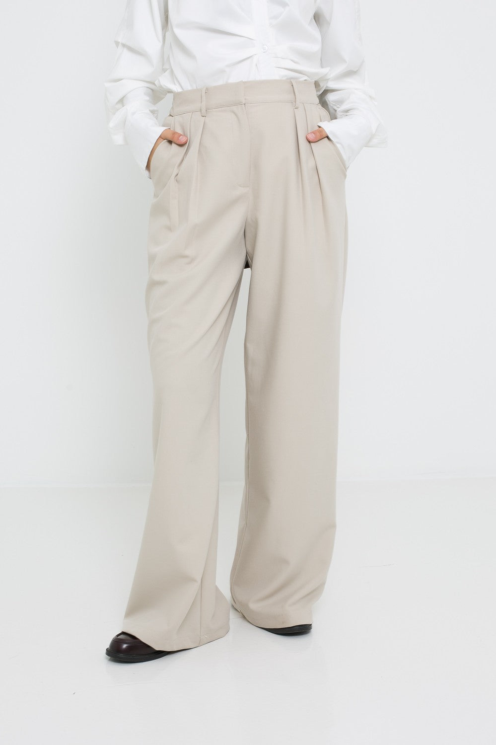 Pantalon ample tailleur pour femme. Détail plis ceinture et poche.