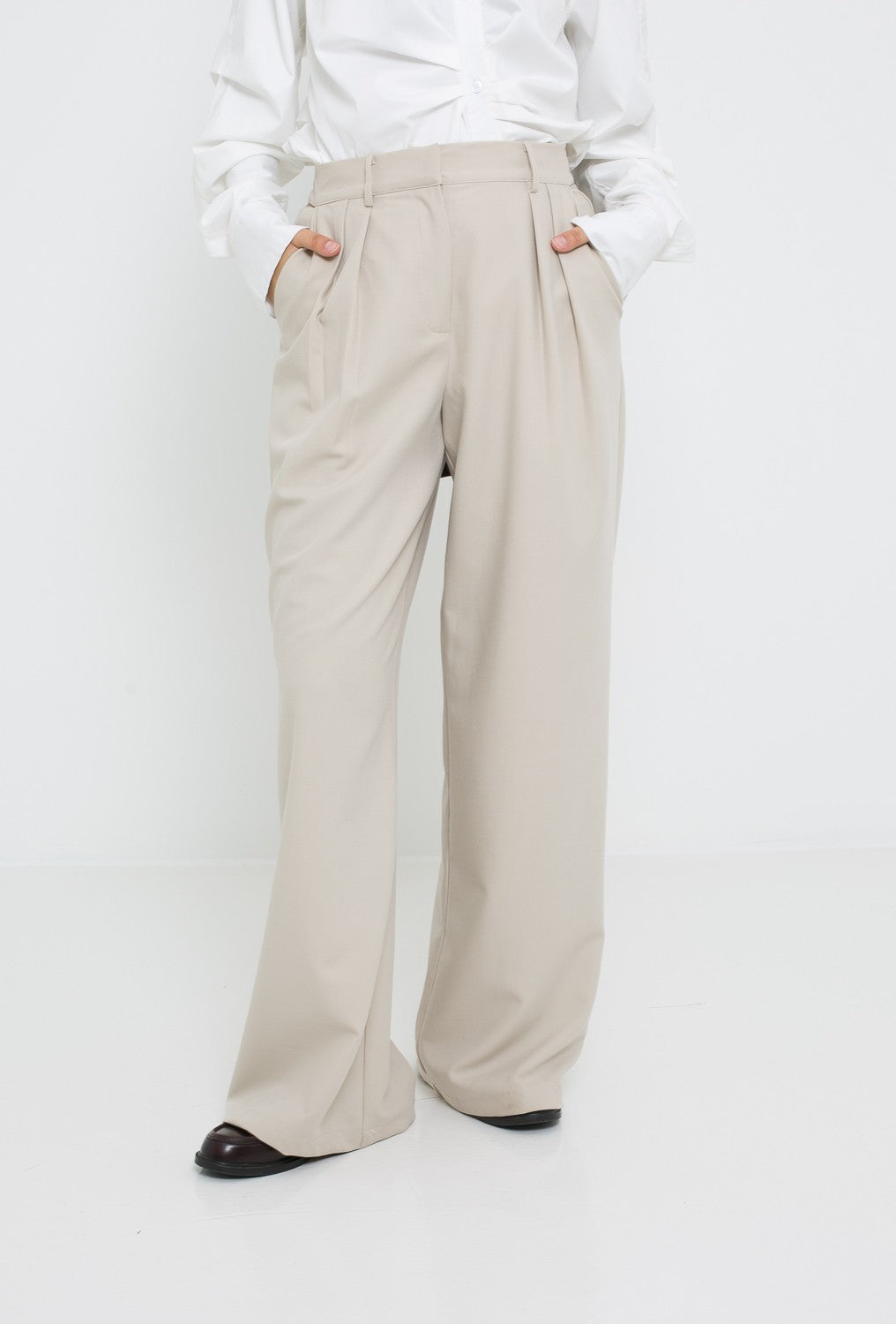 Pantalon ample tailleur pour femme. Détail plis ceinture et poche.
