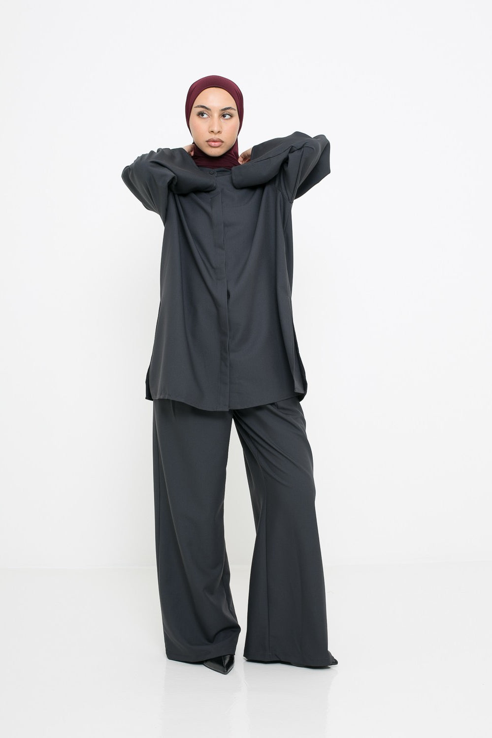 Pantalon à pince classe gris foncé porté avec une chemise longue d'hiver pour femme musulmane