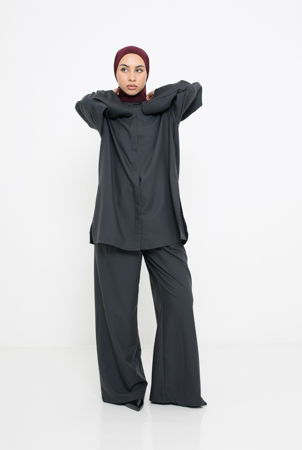 Pantalon à pince classe gris foncé porté avec une chemise longue d'hiver pour femme musulmane