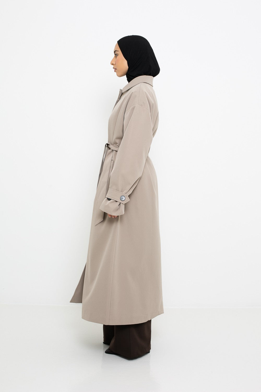 Trench long beige pour femme vue de profil.